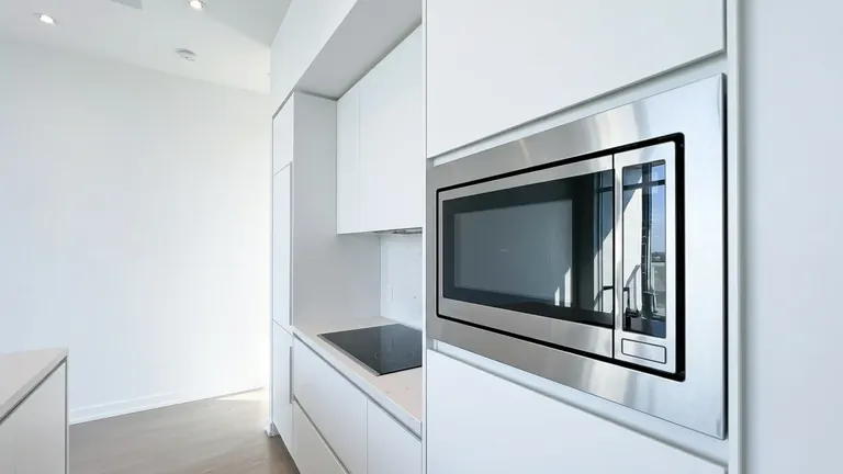 Built-in stainless microwave in clean white cabinetry